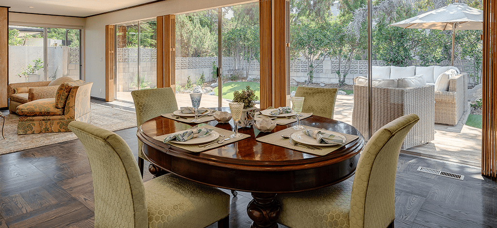 A dining room table with four chairs and plates on it.