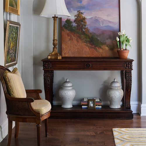 A living room with a chair and painting on the wall