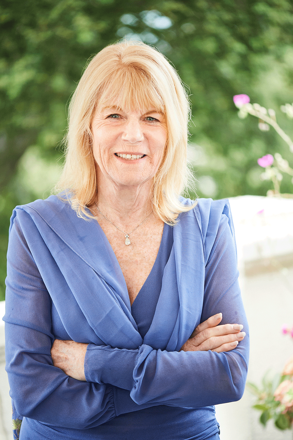 A woman in blue shirt with arms crossed.